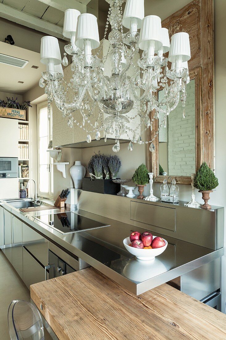 Blick in die Küche mit rustikalem Holz, Edelstahl und Kronleuchter