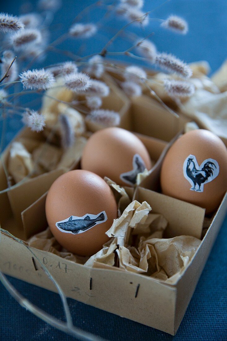 Easter eggs decorated with animal stickers in vintage cardboard box