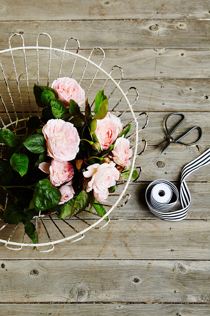 Delicate pink roses in a wire basket
