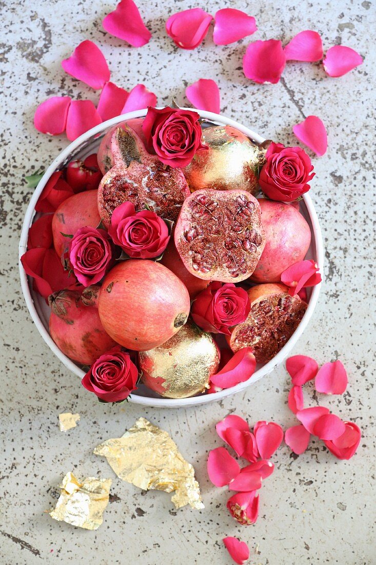 Granatäpfel und Rosenblüten in einer Schale