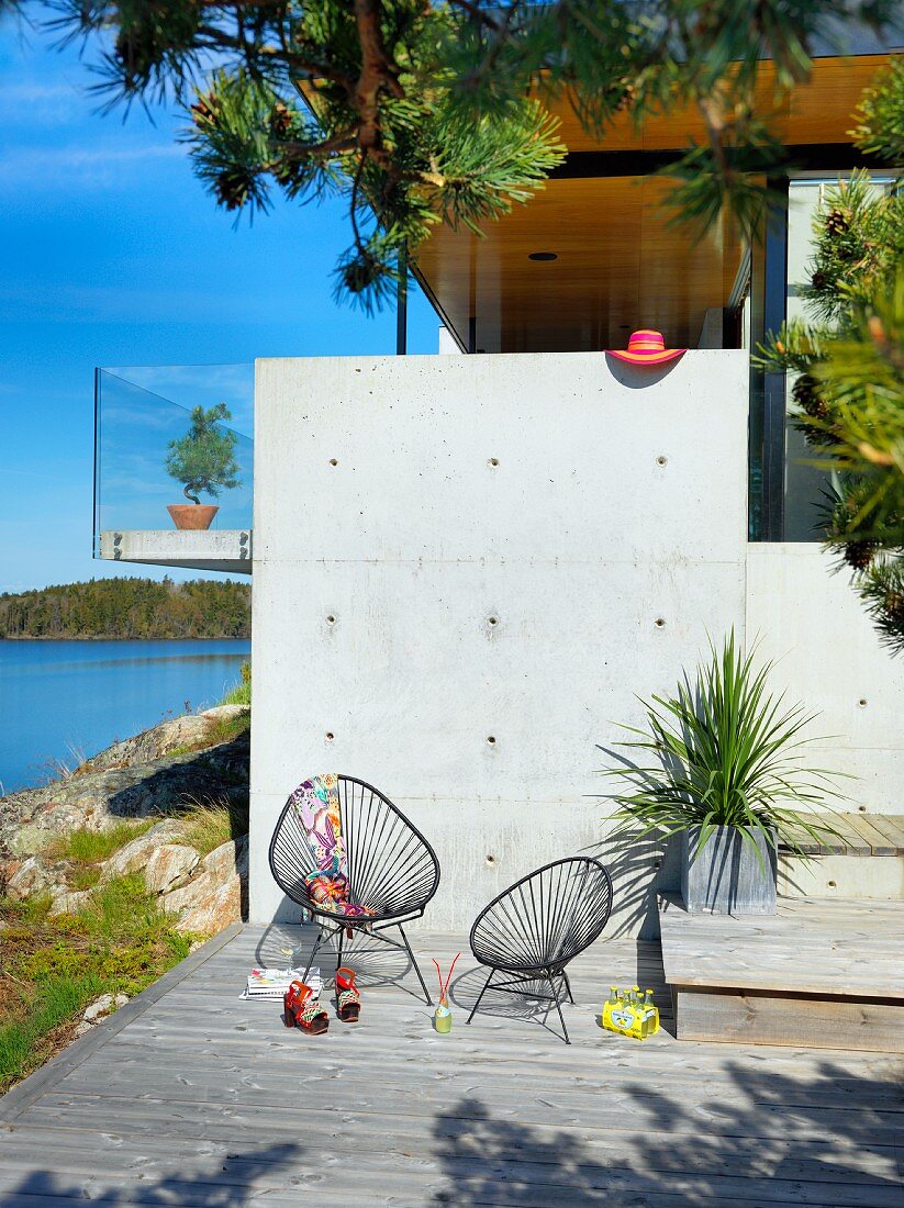 Black retro garden easy chairs on terrace with concrete wall