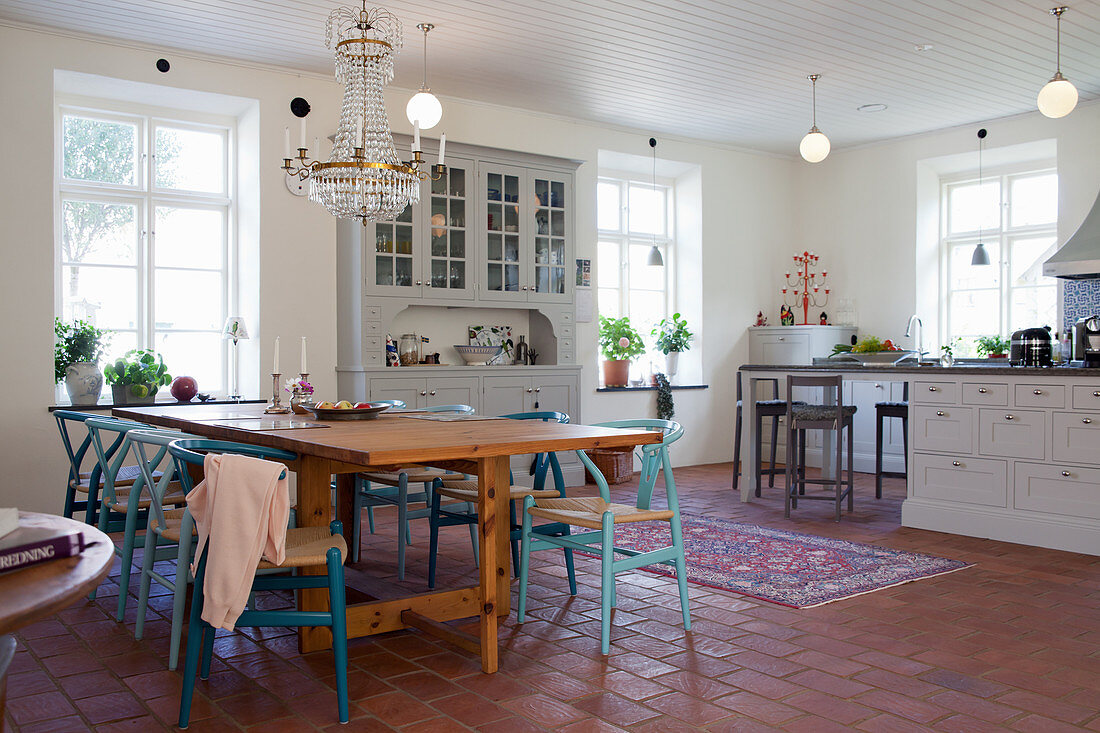 Esstisch mit blauen Designerstühlen in Wohnküche im Landhausstil
