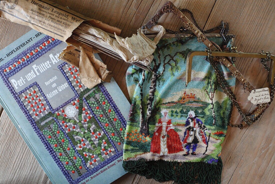 Ancient craft of beading: bag with courtly scene next to instruction book