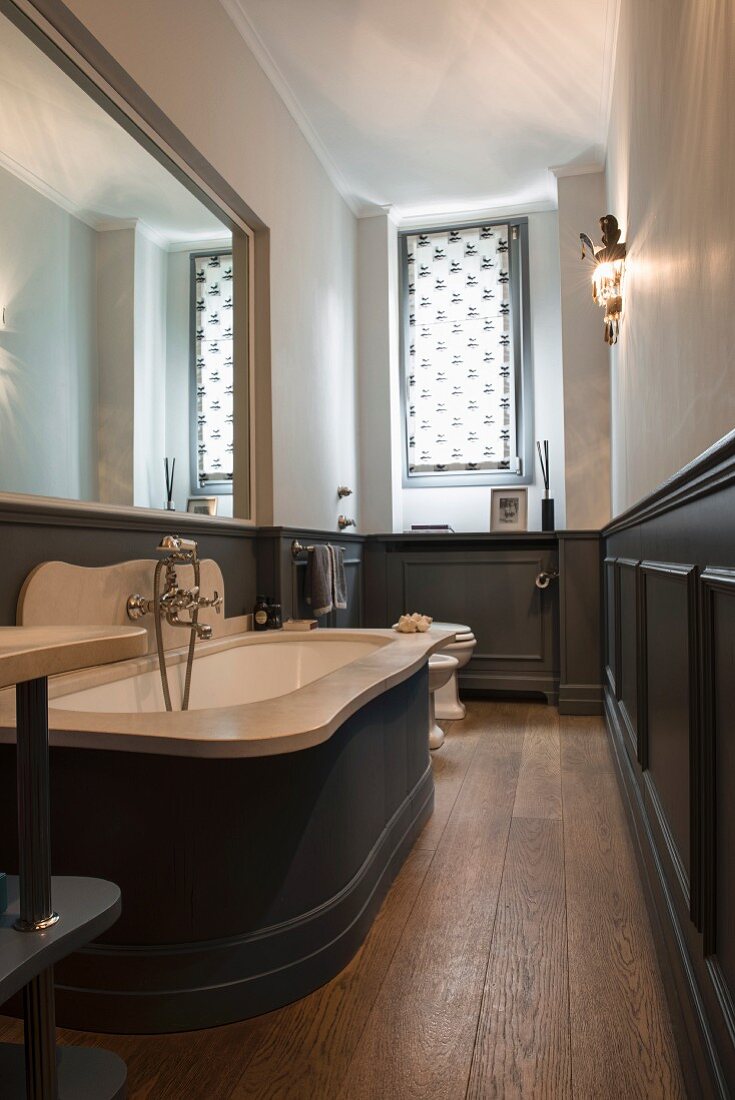 Wainscoting and large mirror in narrow bathroom