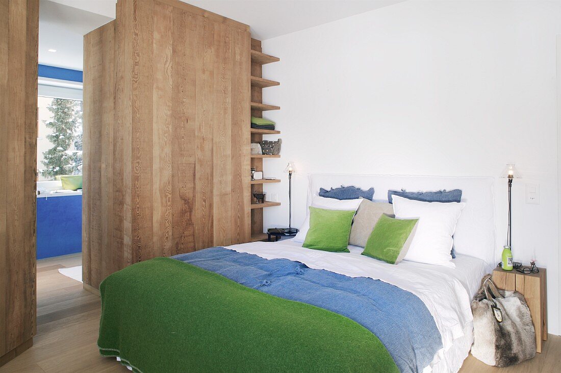 Viel Holz im alpinen Schlafzimmer mit Blau und Grün
