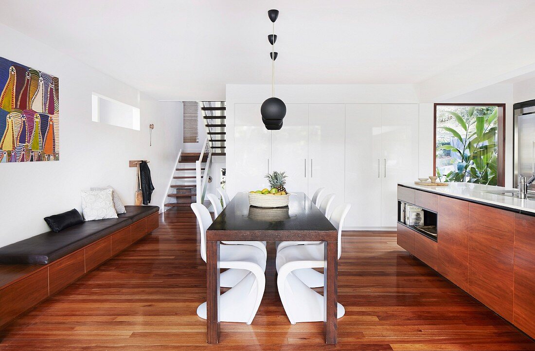 Elegante Designerküche mit Edelholzfronten, Essbereicht und Sitzbank