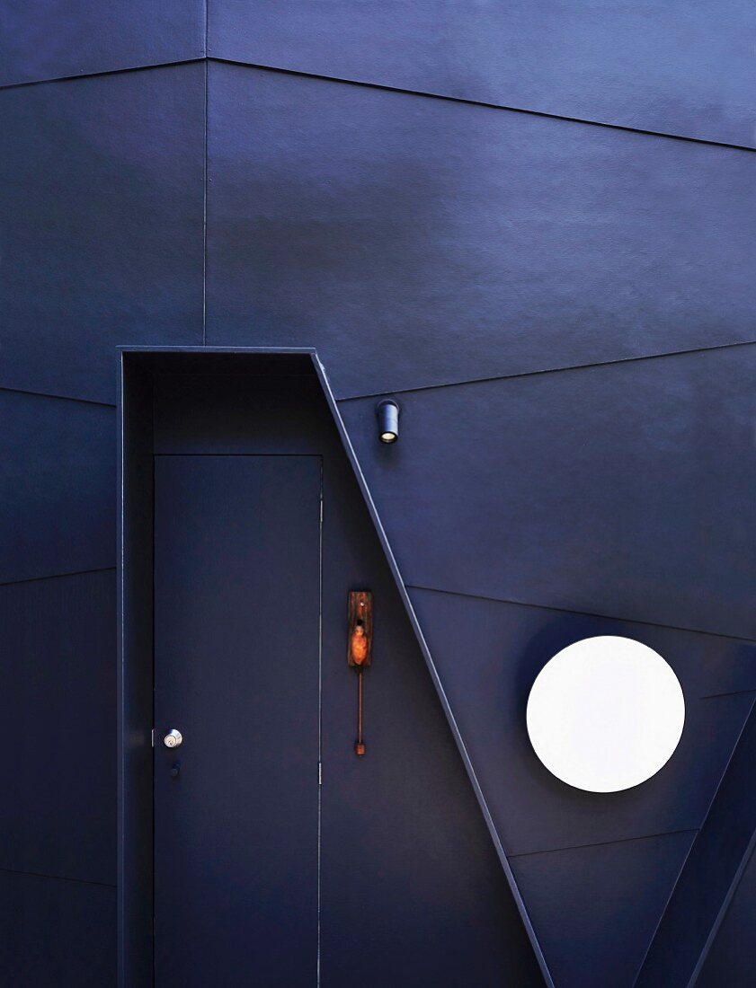 Designer-Eingangstür in dunkler Fassade