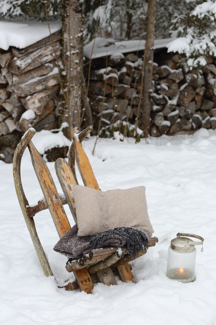 Old wooden sledge used as Viking chair in snowy garden