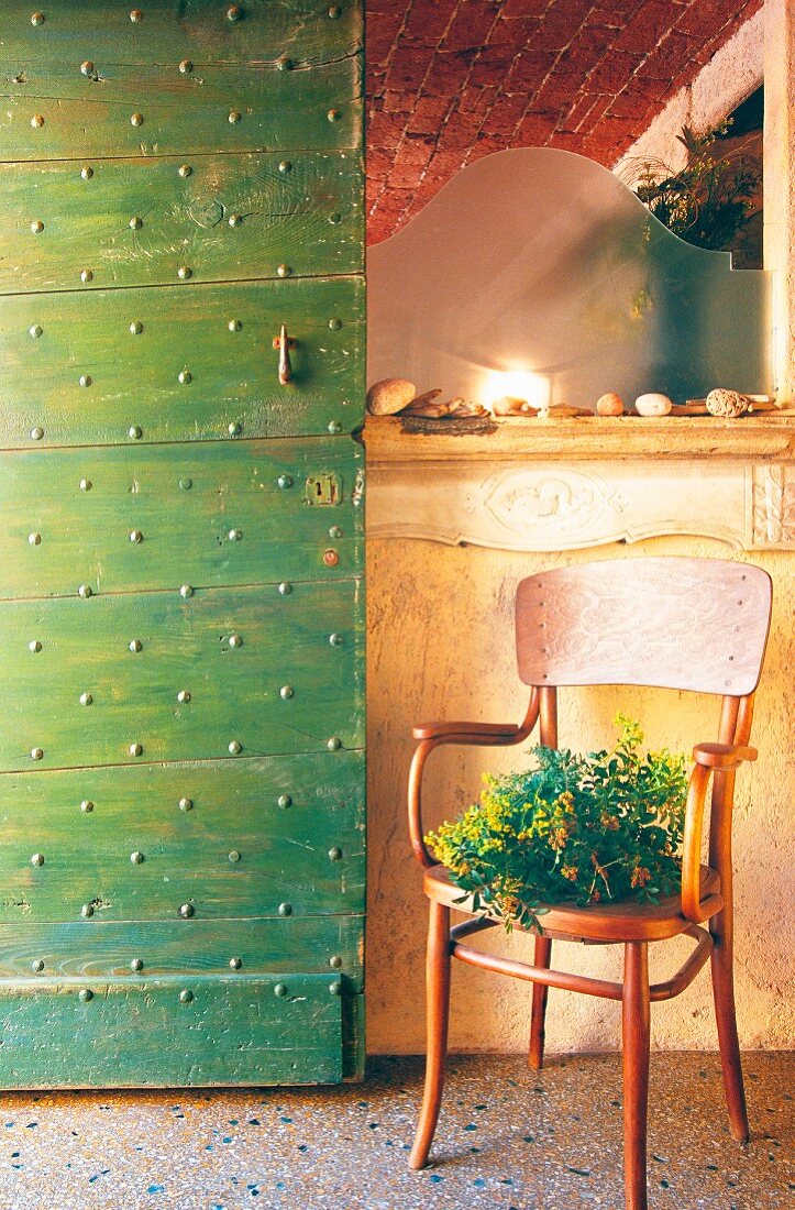 Retro Stuhl auf Terrazzoboden neben grüner Vintage Tür