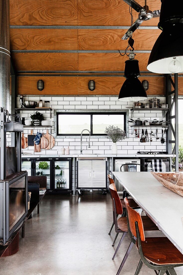 Offene Küche im Industriestil, mit Betonboden, U-Bahn-Fliesen und holzverkleideter Decke