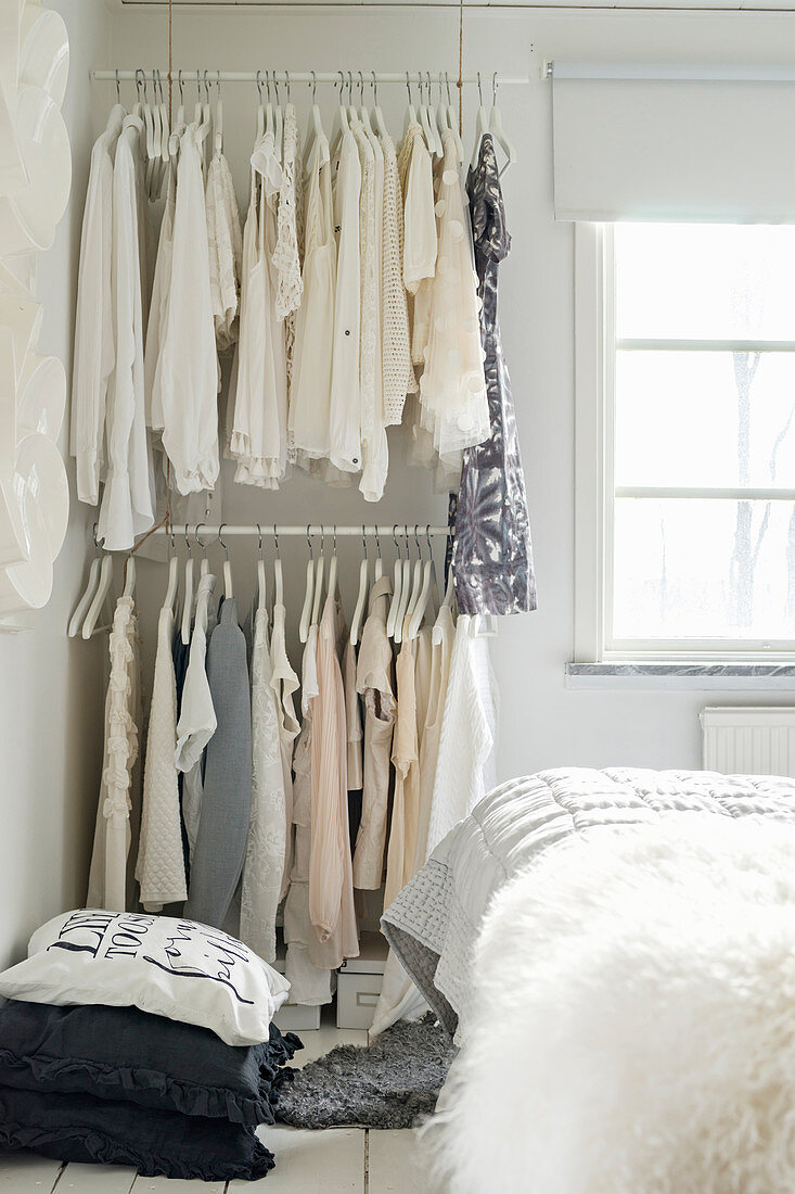Pale clothing on two clothes rails one above the other
