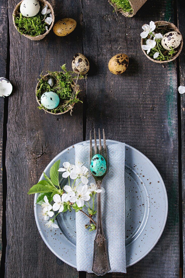 Österliche Tischdeko mit bunten Wachteleiern, Moos und Kirschblüten