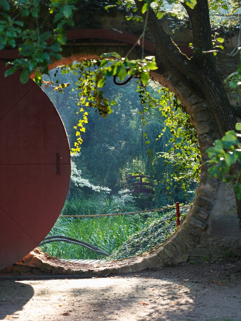 View through round doorway into lush garden