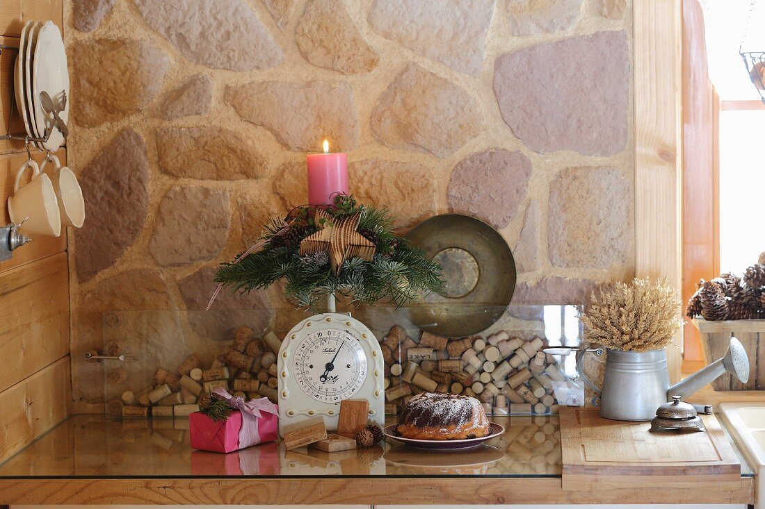 Kuppelförmiges Adventsgesteck mit einer Kerze und Holzstern auf Vintage Küchenwaage