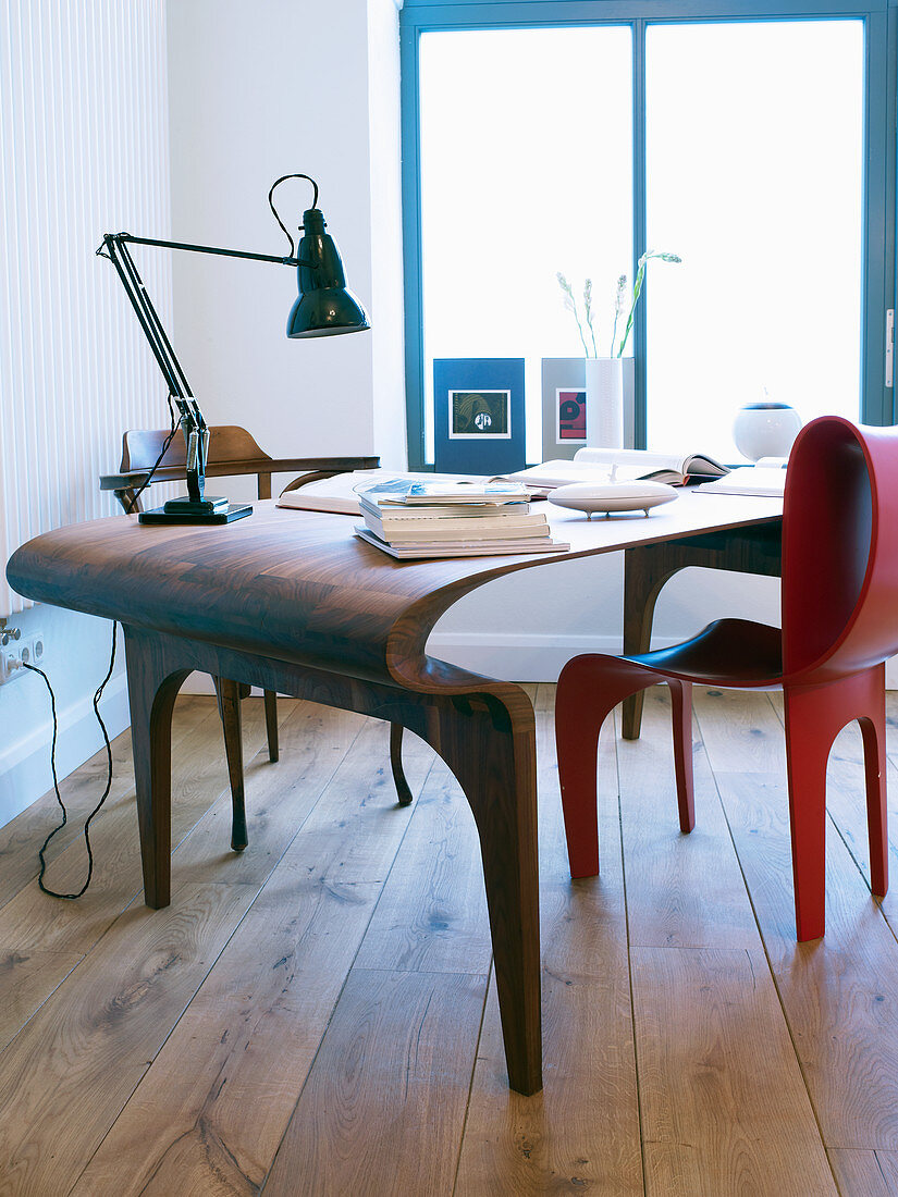 Futuristisch geformter Schreibtisch aus Holz und roter Stuhl