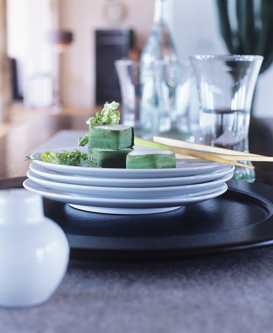 Sushi on stack of white plates