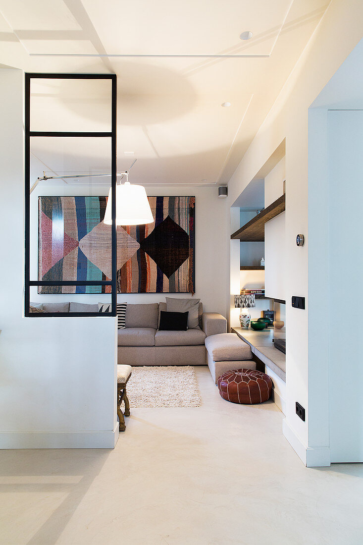 Offener Durchgang zum Wohnzimmer mit Glaswand und Wandteppich