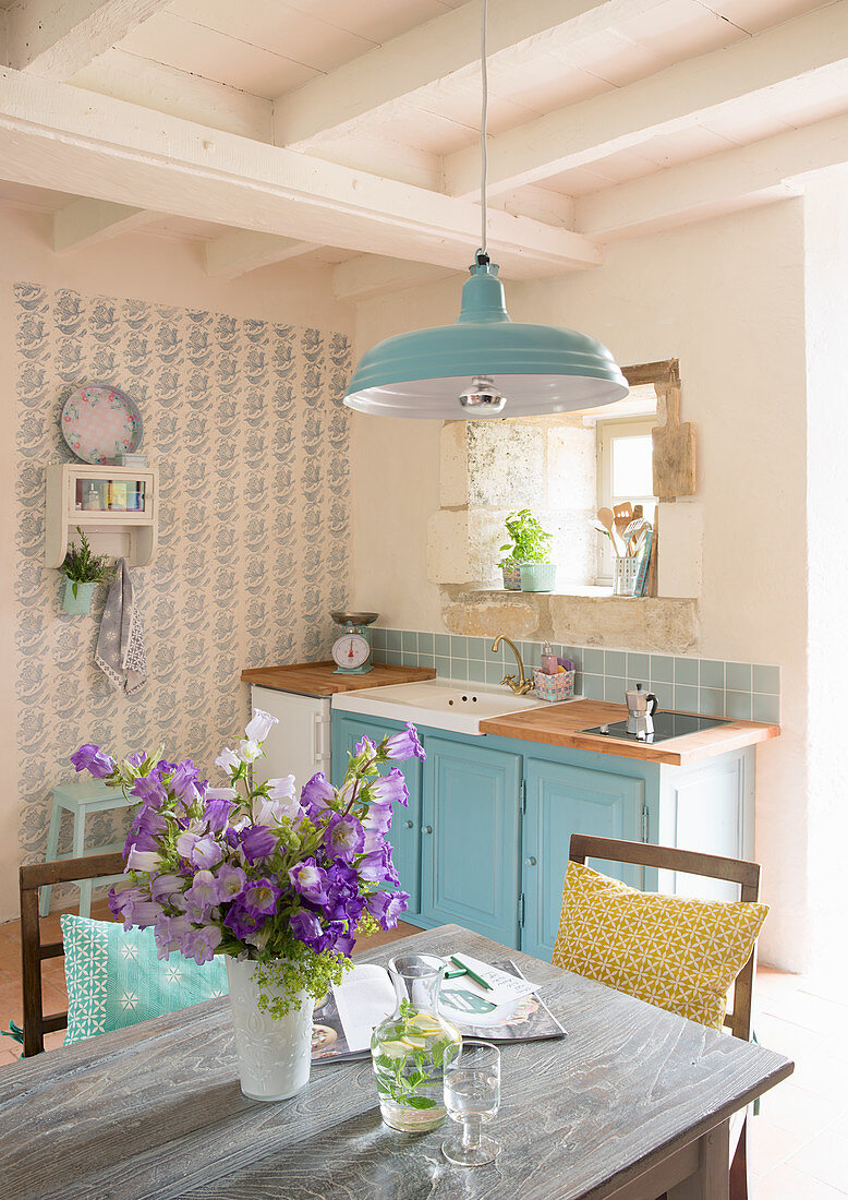 Vase of flowers on table in country-house kitchen