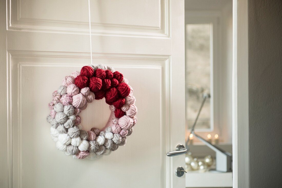 Hand-made door wreath decorated with small balls of wool