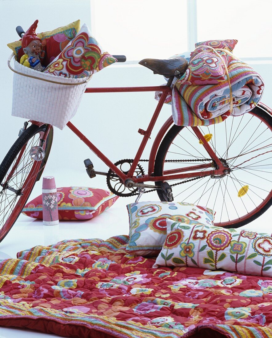 Indoorpicknick mit rotem Fahrrad und geblümten Textilien
