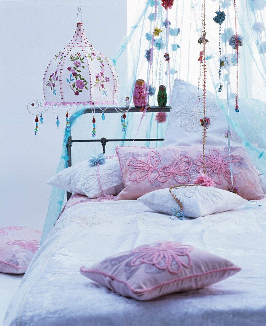 Romantisches Bett mit Baldachin und Lampe im Hippiestil