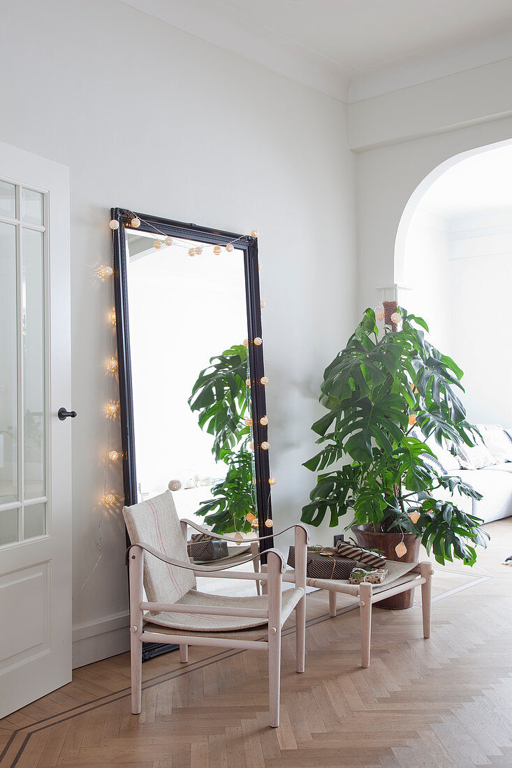Scandinavian designer chair in front of mirror surrounded by fairy lights