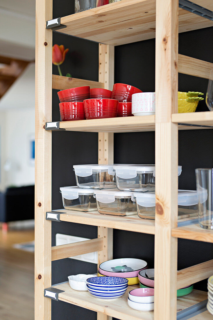 Crockery and storage containers on simple wooden shelves