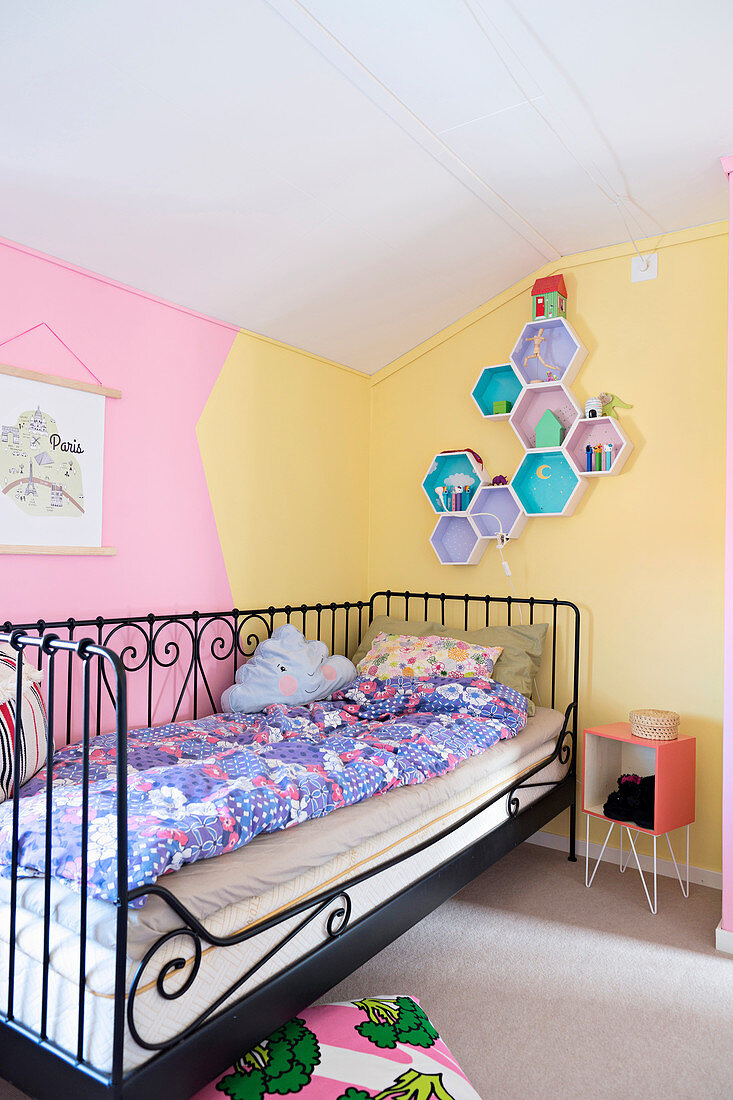 Metallbett vor zweifarbig gestrichener Wand im Kinderzimmer