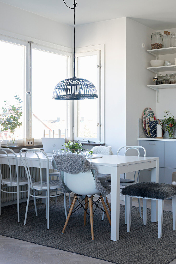 Esstisch mit verschiedenen Stühlen in heller Wohnküche
