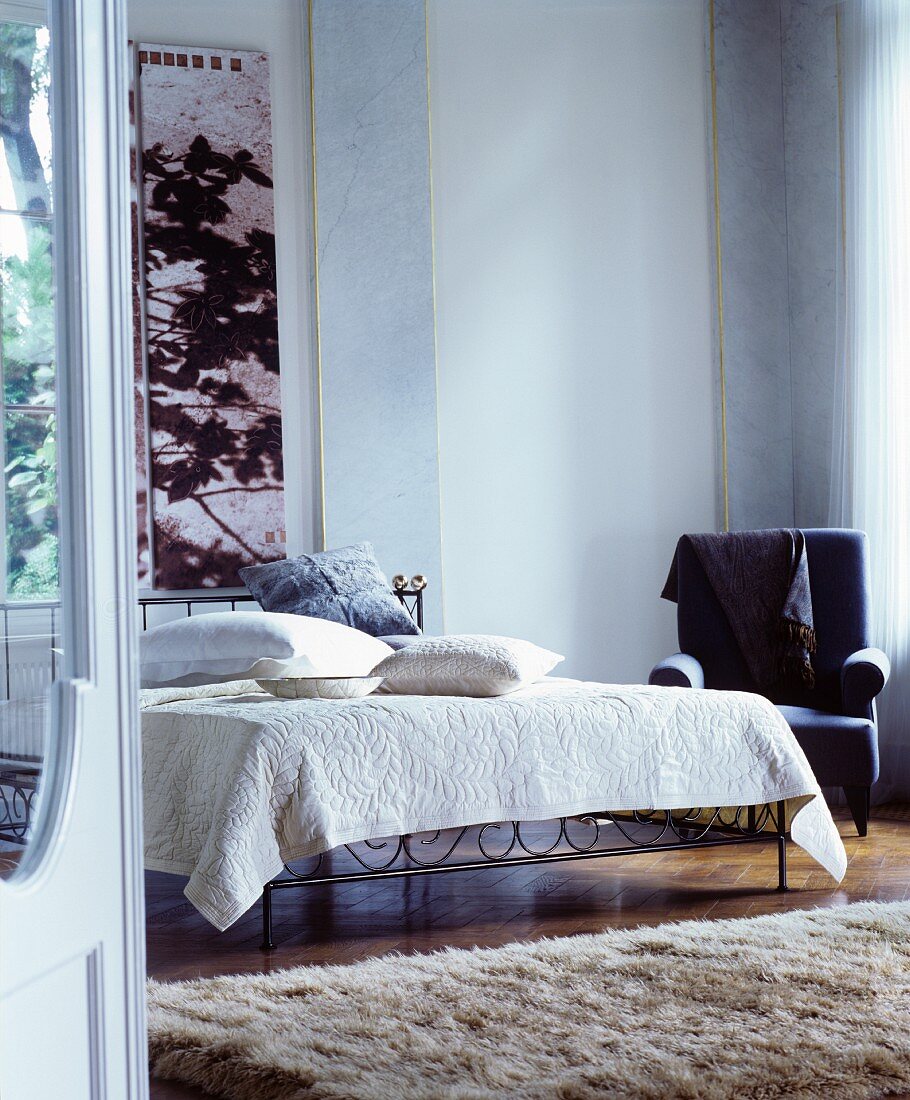 Klassisches Schlafzimmer mit Metallbett und Teppich