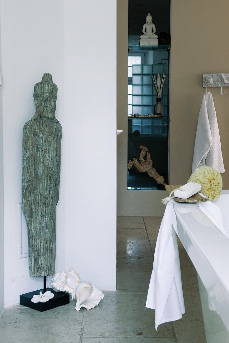 Exotische Figur und Naturdeko im Badezimmer in Weiß und Beige