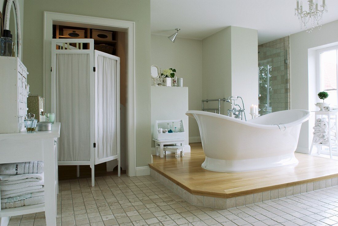 Free-standing bathtub on platform in vintage-style bathroom
