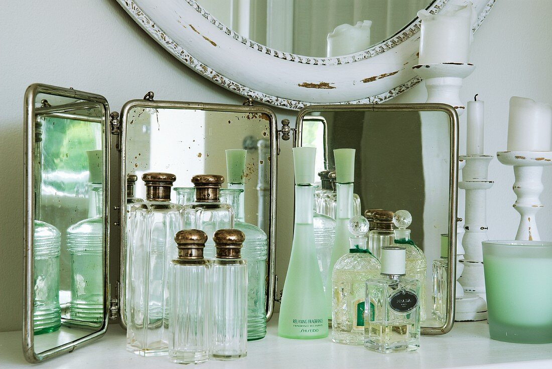 Sammlung von nostalgischen Flakons und Parfums vor Spiegel