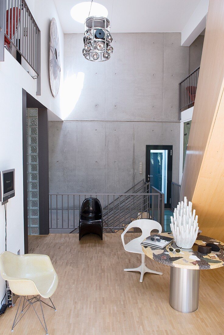 Flur im Architektenhaus mit Betonwand und Designerstühlen