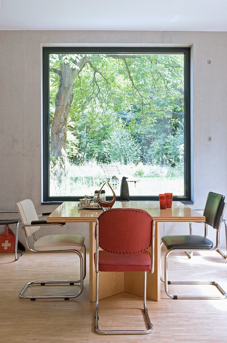 Retro cantilever chairs around wooden table in front of panoramic window