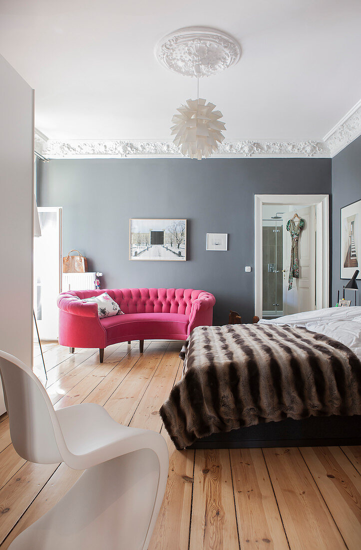 Halbrundes pinkes Sofa im Schlafzimmer mit grauen Wänden