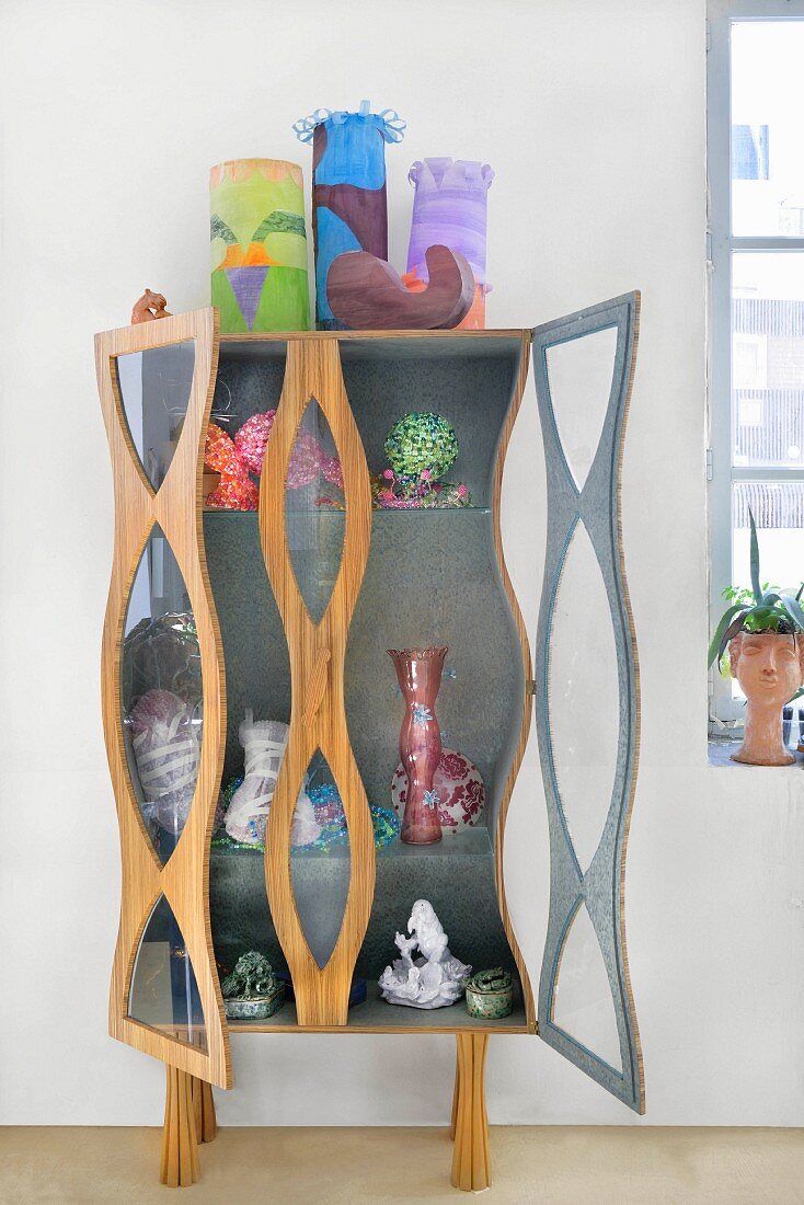 Collection of artworks on and in sculptural cabinet