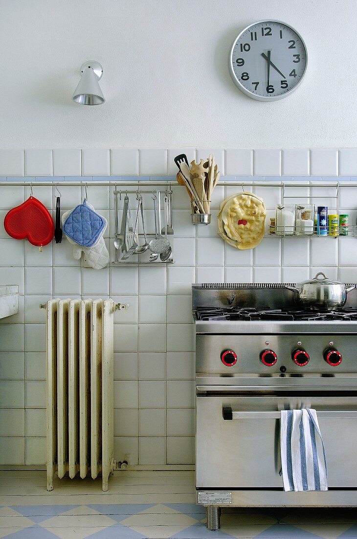 Kitchen utensils hung above gas cooker in retro kitchen