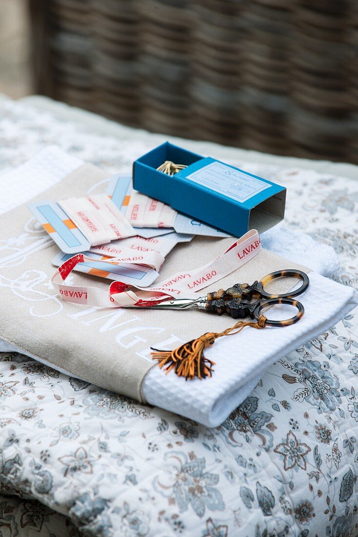 Scissors, tassel and ribbons on folded fabric