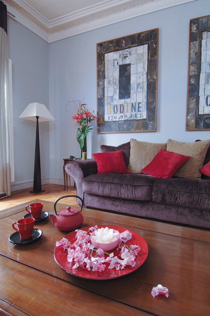 Blumen und Teekanne im Wohnzimmer in Rottönen