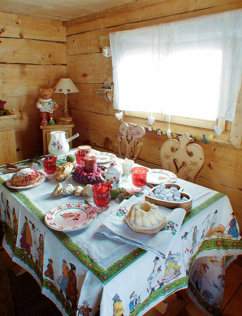 Weihnachtlich gedeckter Tisch in einer rustikalen Holzhütte