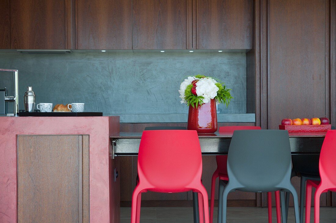 Red and black plastic chairs around table in kitchen