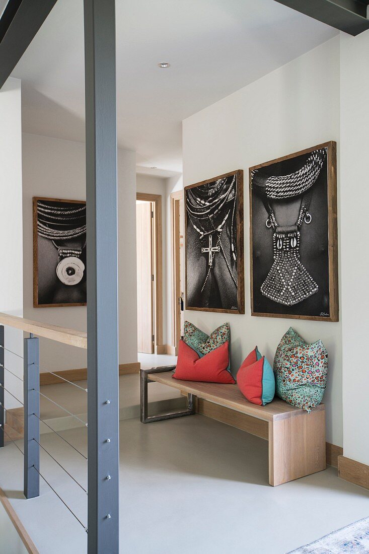 Pictures of African jewellery above colourful cushions on bench