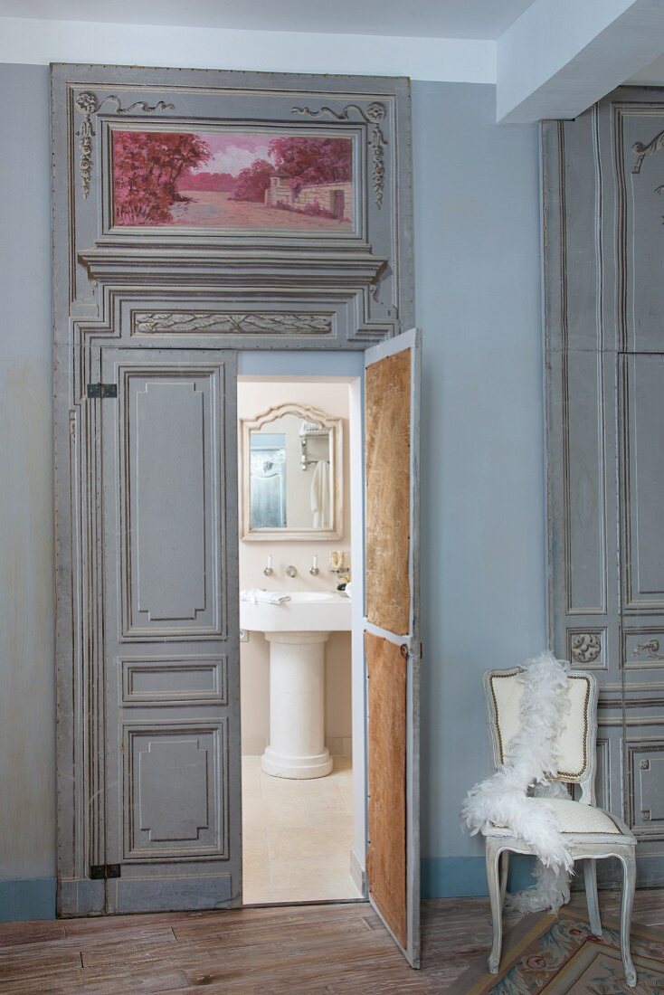 View into vintage-style bathroom through ornate double doors