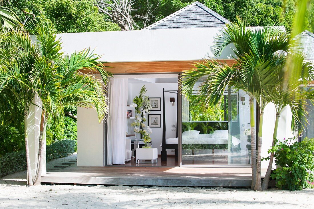 Modernes Strandhaus zwischen Palmen; Einblick in eleganten Schlafbereich