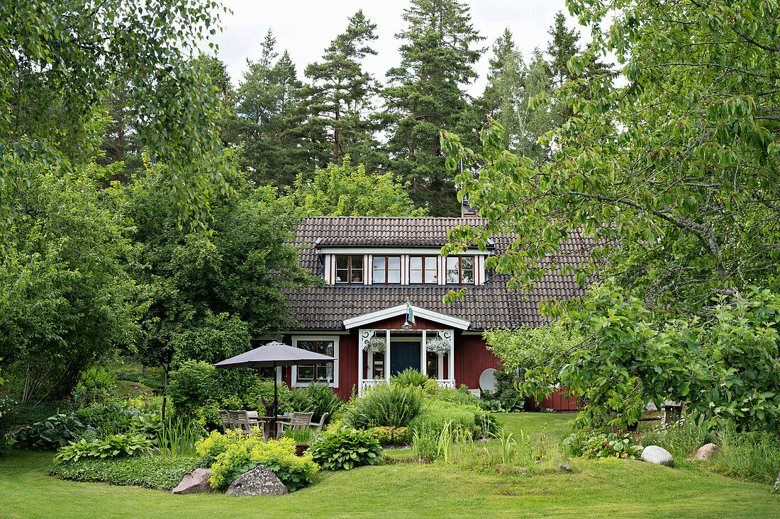 Schwedenhaus umgeben von üppigem Garten