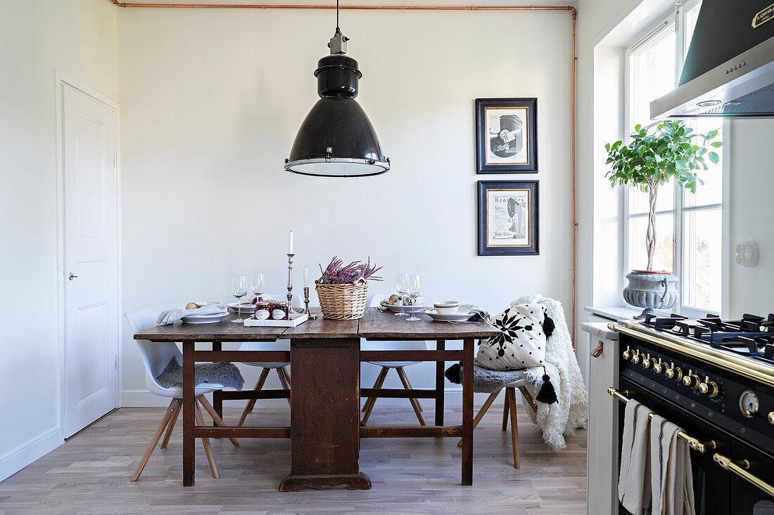 Alter Holztisch mit modernen Stühlen in der Küche mit Gasherd