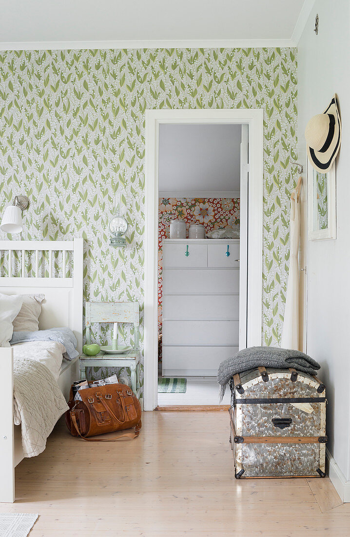 Blick vom Schlafzimmer mit grün gemusterter Tapete ins Nebenzimmer