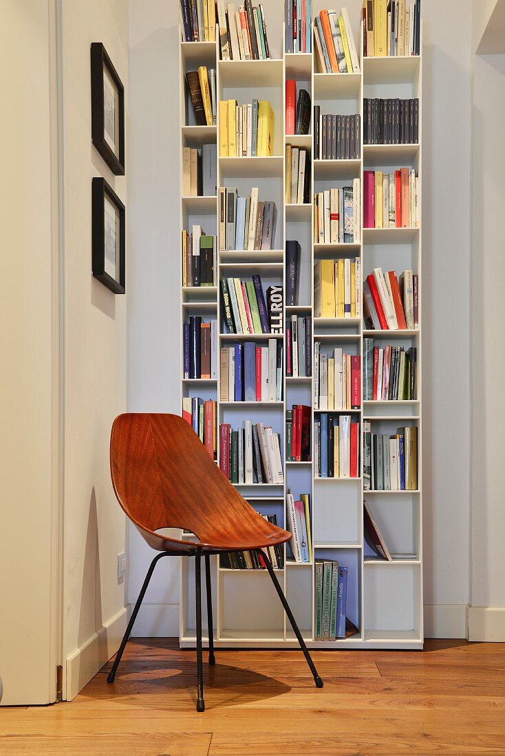 Leseecke mit weißem Bücherregal und Retrostuhl in Altbauwohnung