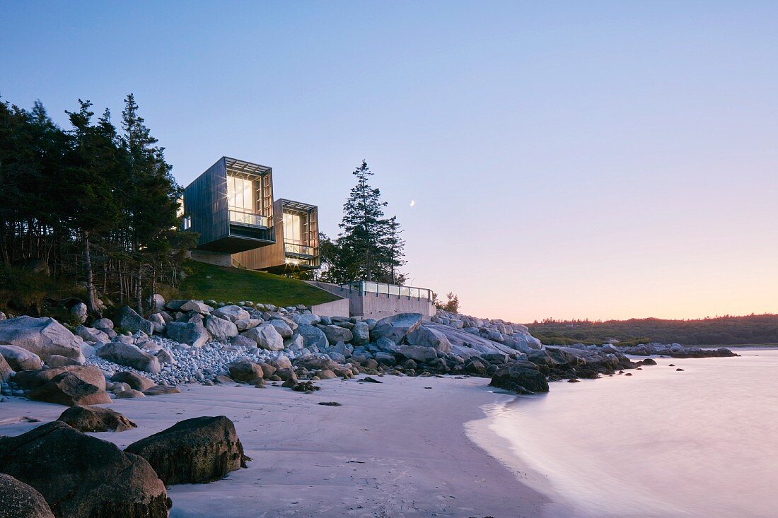 Two modern beach-houses on coast at twilight